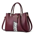Deep burgundy leather handbag with snakeskin pattern stripes and gold hardware accents - Burgundy