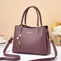Elegant purple leather handbag with gold hardware and heart pearl charm detail - Purple