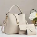 Detailed macro of cream faux leather handbag set with lychee grain and gold hardware - Off White