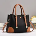 Detail of lychee textured leather tote with contrasting brown accents and gold hardware - Black