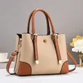 Detail of lychee textured handbag with contrast stitching and golden hardware accents - Khaki