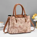 Close-up of beige jacquard floral texture and brown leather trim on a retro handbag - Earthy Yellow