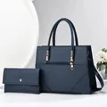 Detail view of deep blue leather tote bag and matching clutch with gold hardware - Blue