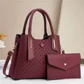Burgundy embossed woven handbag set with gold hardware and adjustable strap in studio - Red