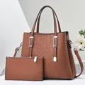 Dettaglio della borsa tote marrone effetto coccodrillo con pochette e finiture argentate - Giallo Terra