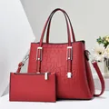 Dettaglio della borsa tote in pelle rossa goffrata e pochette coordinata con finiture argento - Rosso