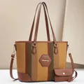 Detail view of striped canvas tote bag with brown leather handles and matching small pouch - Earthy Yellow