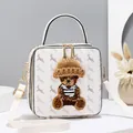 White box bag with deer print, featuring a plush bear in a knit hat and gold hardware - White