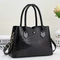 Detail of glossy octopus texture faux leather and golden hardware on black handbag - Black