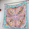 Pañuelo de seda rosa con flores de margarita y texto lucky colgado en una barra de metal - Rosa