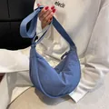 Bolso de media luna de nailon azul con correa ajustable mostrado en modelo real - Azul Niebla