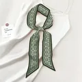 Detailed macro view of deep green paisley twilly scarf with a silky satin texture - Dark Green Paisley