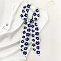 Dettaglio di sciarpa in seta con fiori blu scuro legata su raso bianco lucido - Floreale Bianco Navy