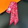 Detail of red patterned silk scarf twilly with washing label on black background - Red Print (C248-2)