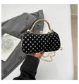 Elegant black evening bag with white polka dots, gold handle, and diamond clasp closure - Black