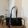 Minimalist black faux suede baguette bag with stylish contrast charm and long shoulder straps - With Pendant / Black