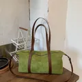 Green suede baguette bag with brown leather straps on a dark wooden table background - With Pendant / Green