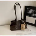Detail of dark brown leather tote bag featuring a cute plush dog pendant and soft texture - With Pendant / Coffee