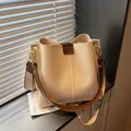 Creamy white bucket bag with brown leather trim and golden hardware detailing - Khaki
