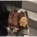 Dunkelbraune gesteppte Eimertasche mit Kettenriemen und einem Plüsch-Hundeanhänger - Kaffeebraun