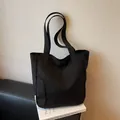 Borsa tote in tela nera minimalista con tasca frontale e ricamo a lettere - Nero