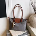Sac fourre-tout gris en nylon avec rabat en cuir brun et breloque perlée sur valise - Gris