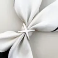 Detailed close-up of X-shaped silk scarf buckle in gold finish with white enamel inlay - Triple Ring White / Gold