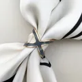 Detail view of X-shaped silk scarf ring in gold and grey enamel on a striped scarf - Triple Ring Gray / Gold