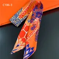 Detailansicht eines orangefarbenen Seidenschals mit Giraffenmuster für Taschengriffe - 88x5cm