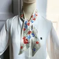 Detailansicht eines eleganten Seidenschals mit Blumenmuster auf weißem Hemd - T396-1 / Cremegelb