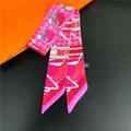 Close-up of pink silk twilly scarf with horse motifs and luxury branding style details - Pink Printed (C215-3)