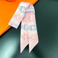 Detail of pink silk twilly scarf with blue and red character illustrations for handbags - Pale Pink (C231-3)