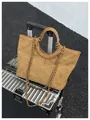 Brown quilted tote bag with chain strap and cutout handle on a silver suitcase - One Size / Brown
