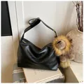 Retro black leather hobo shoulder bag featuring a large plush lion charm with gold buckle - With Pendant / Black