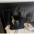 Detail of black Hobo bag with wooden bead charm and gold flower logo buckle - With Pendant / Black