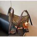 Detail der Canvas-Tasche mit Leopardenmuster, braunem Lederriemen und Plüsch-Anhänger - Mit Anhänger / Braun