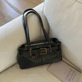 Borsa sottobraccio retrò in pelle nera con finiture dorate su divano beige - Con Ciondolo / Nero