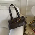 Borsa sottobraccio vintage marrone scuro in similpelle con fibbie dorate sul divano - Con Ciondolo / caffè
