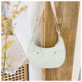 Detail of crescent nylon bag featuring dual front zippers and adjustable wide strap - One Size / White