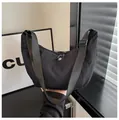 Detalle de bolso hobo de nailon negro con correa ajustable y cierre de cremallera fina - Talla única / Negro