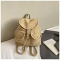 Vista detallada de la mochila vintage amarilla con solapa frontal y dos hebillas de bolsillo - Caqui