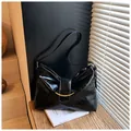 Minimale schwarze glänzende Achsel-Einkaufstasche mit Faltenstruktur und Gold-Schnalle - Unterarmtasche / Schwarz