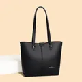 Detalle de la textura de cuero negro granulado y el logo dorado en el bolso tipo tote bag - Talla única / Negro