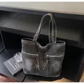 Detail of vintage black washed denim tote bag with dual metal zippers and long tassels - One Size / Black