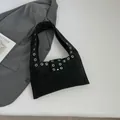 Minimalistische schwarze Wildleder-Einkaufstasche mit silbernen Metallösen im Flat-Lay - Schwarz