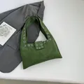 Minimalistische dunkelgrüne Wildleder-Schultertasche mit Metallösen und breitem Riemen - Grün