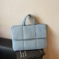 Light blue quilted puffer tote bag with square stitching and top handles for winter - Blue