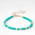 Detailopname van turquoise edelsteenkralen en gouden metalen kralen op de armband - Gefacetteerde turquoise kralenstijl (Armband 3) / 17+3cm