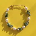 Detail van zoetwaterparel en groene natuursteen armband met gouden karabijnsluiting - Groen steengruis & Natuurlijke zoetwaterparel (Armband A) / 17+3cm