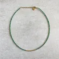 Gros plan du collier en perles de pierre verte avec accents dorés et pendentif en cœur - 38+5cm / Vert avec entretoise dorée